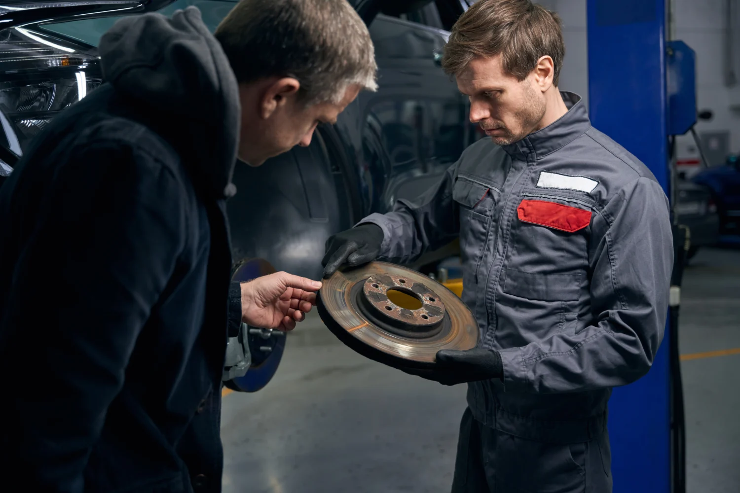 portrait-of-man-holding-brake-disc-talking-with-c-2023-11-27-05-09-19-utc - JC Whitney