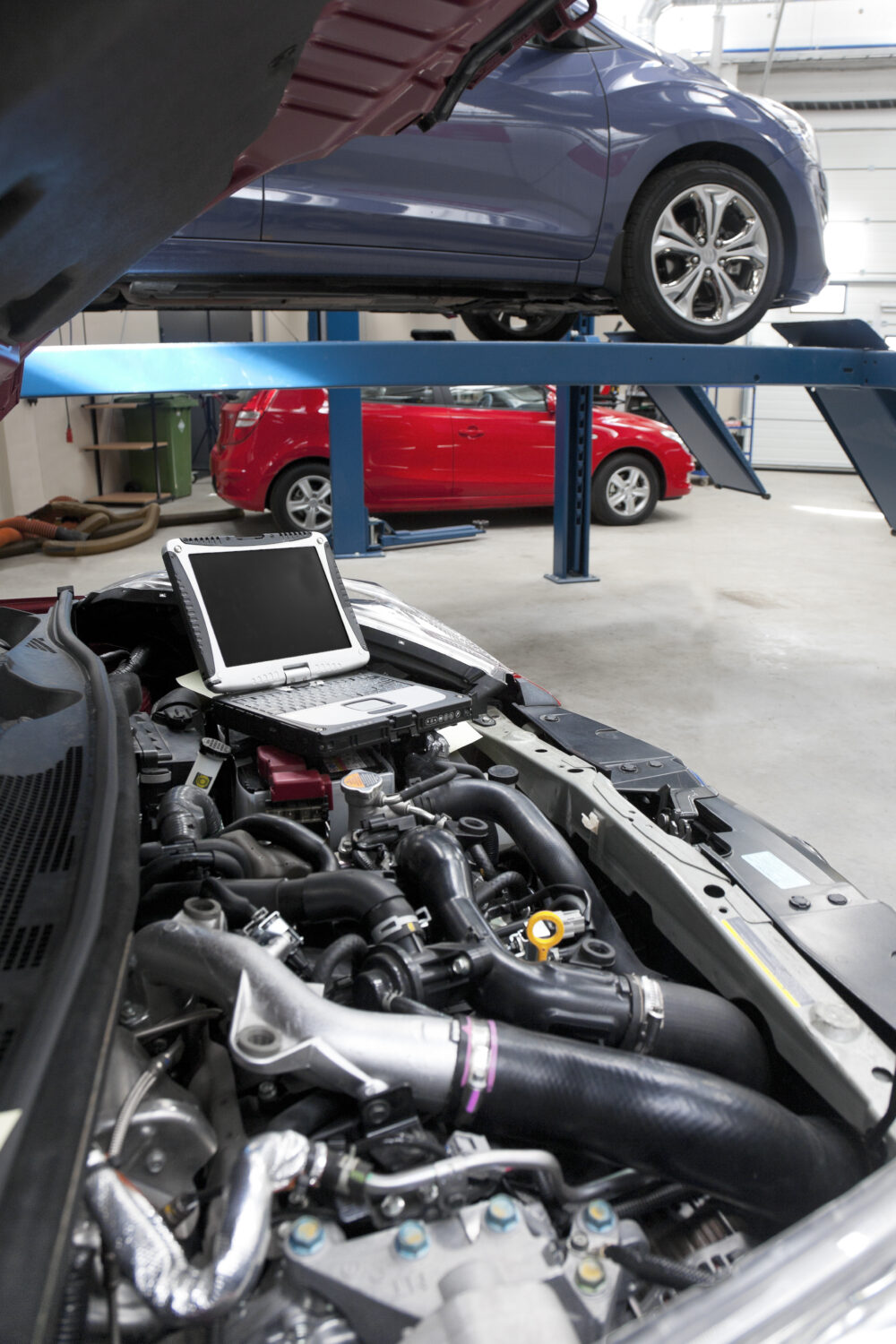 Car repair and maintenanceCar in a workshop and a computer running diagnostics on the engine - JC Whitney