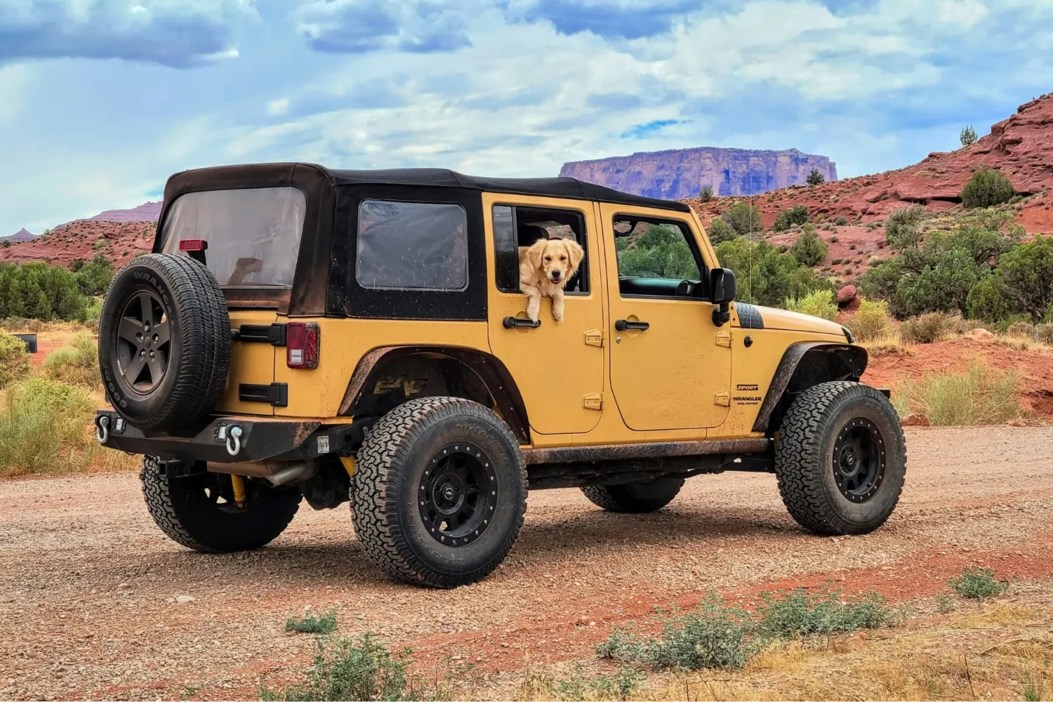 Jeep Wrangler mods - JC Whitney Best Jeep Wrangler mods showcased on a rugged yellow Wrangler with upgraded wheels, tires, and a soft top in a desert landscape.