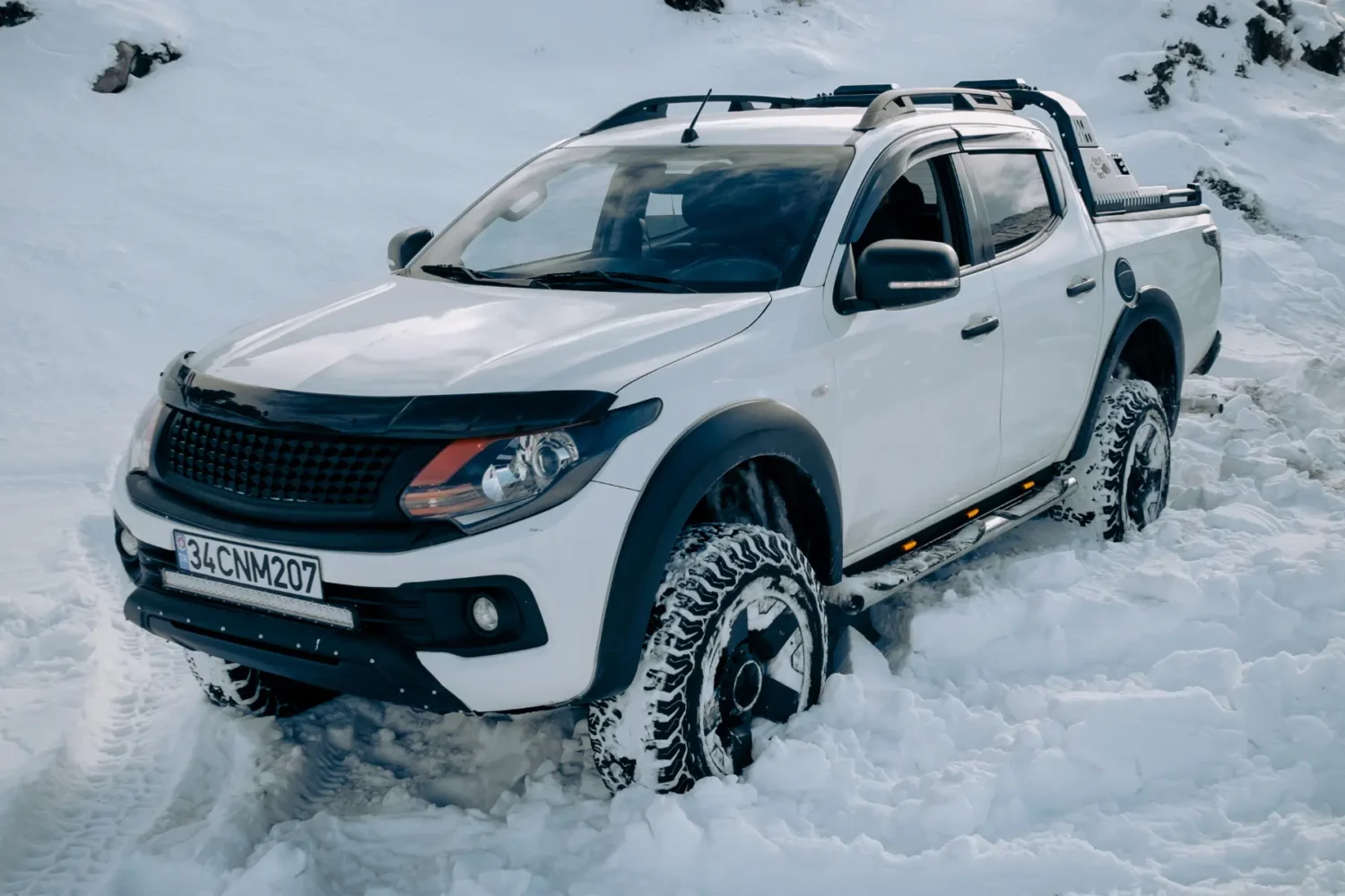truck shock absorbers - JC Whitney Truck shock absorbers in use on a white pickup driving through deep snow.