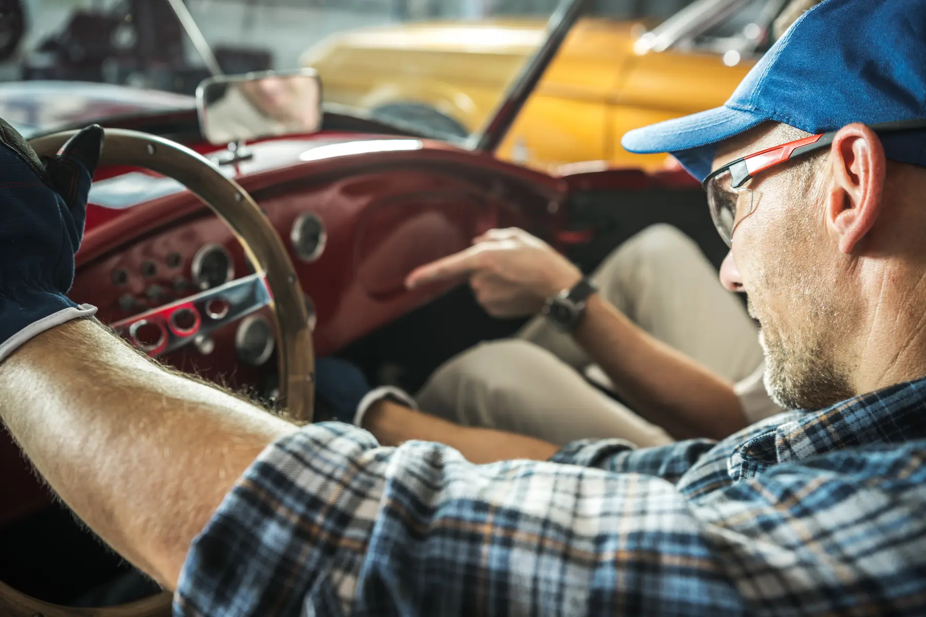 Vintage car parts expert inspecting a classic car dashboard during interior restoration.