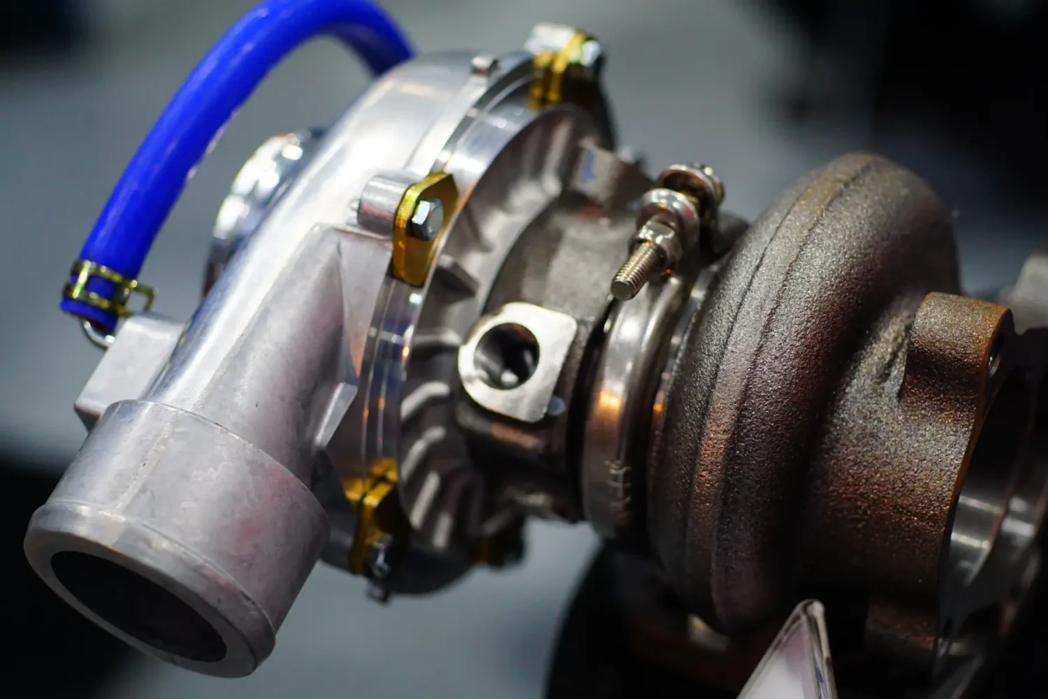 Turbochargers - JC Whitney Turbochargers close-up of a modern high-performance turbo unit with blue vacuum lines.