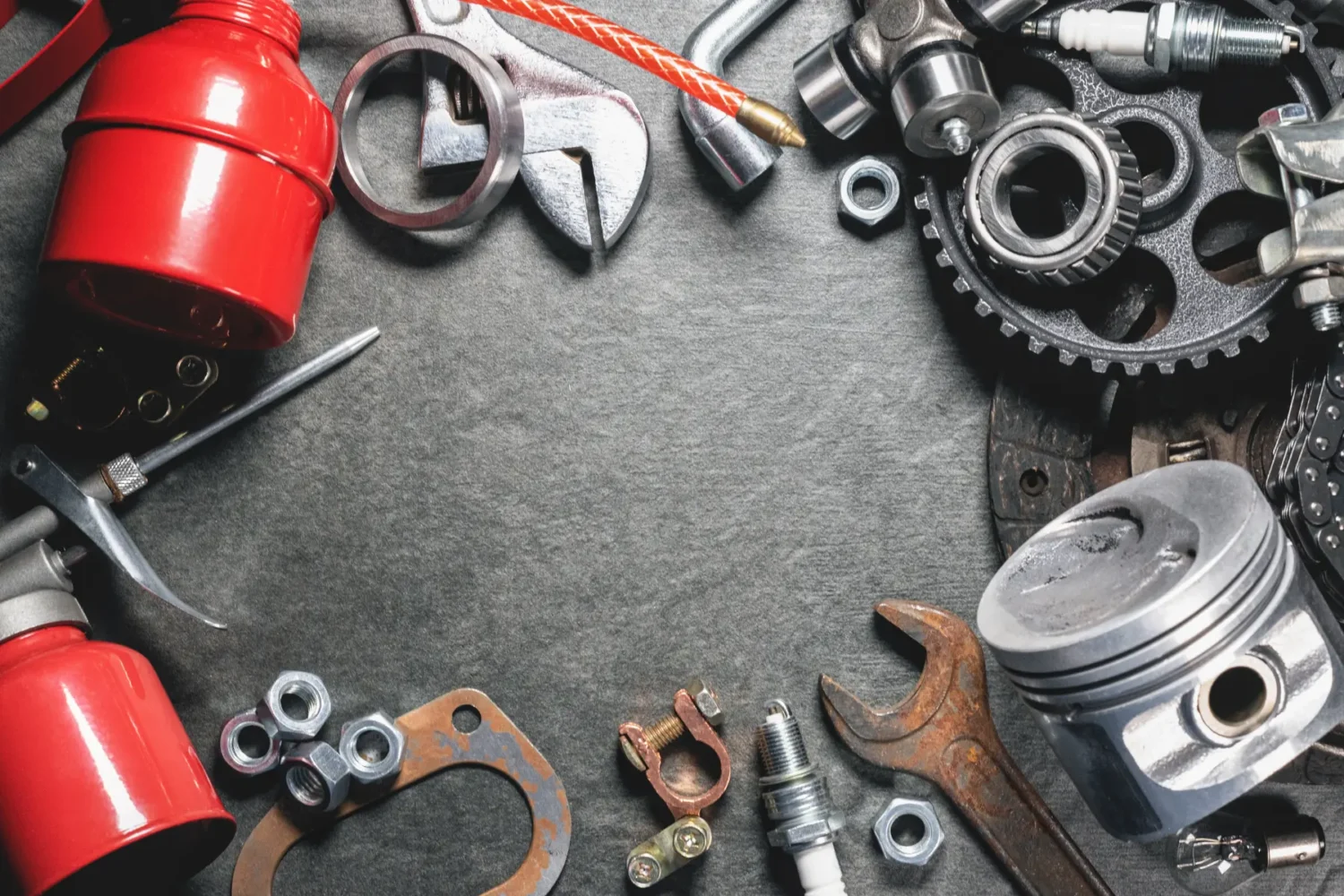 Vintage Vehicle Components - JC Whitney Vintage vehicle components including spark plugs, gears, and gaskets laid out on a workbench.